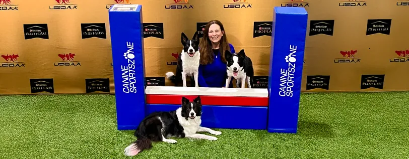 Canine Sports Zone co-owner and director posing with three dogs at North Central Regional Championship.