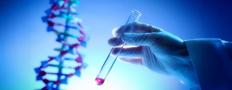 A gloved hand holding a vial with pink liquid at the bottom and a DNA strand model in the background.