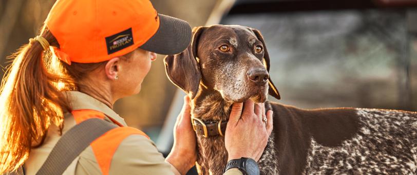 Hunter petting their dog’s neck.