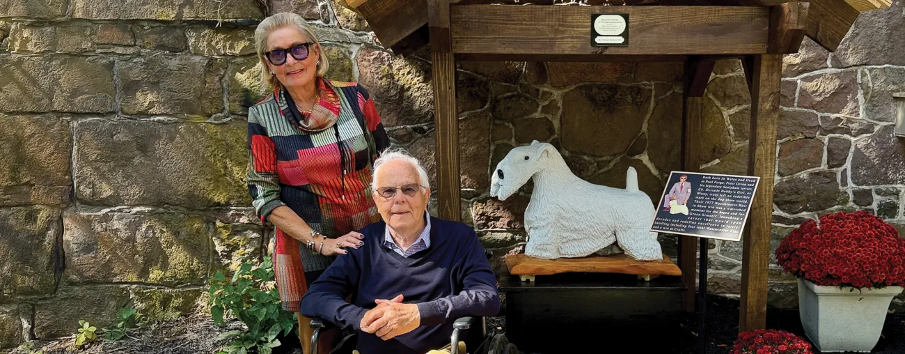 Peter Green posing next to carved statue of famous Sealyham Terrier, Binny.